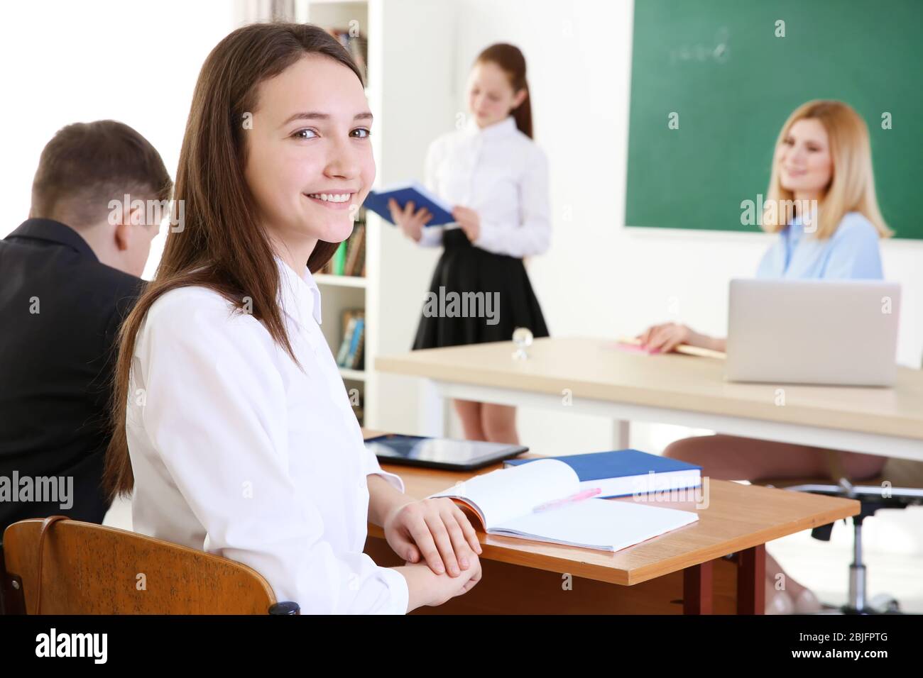 Cute schoolgirl at lesson in classroom Stock Photo - Alamy