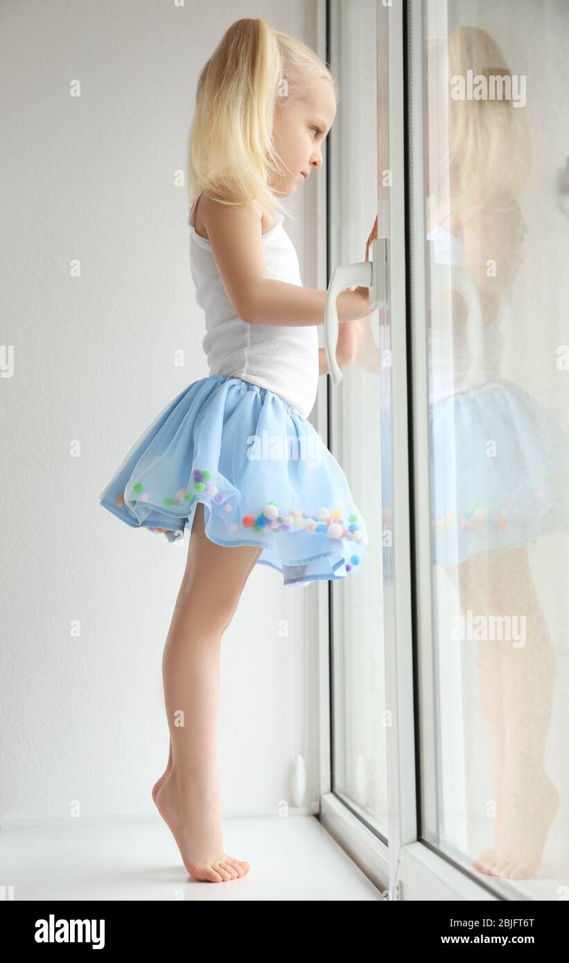 Blonde baby girl standing on patio holding broom Stock Photo - Alamy