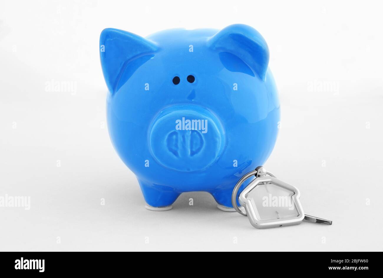 Savings concept. Piggy bank with key on white background Stock Photo ...