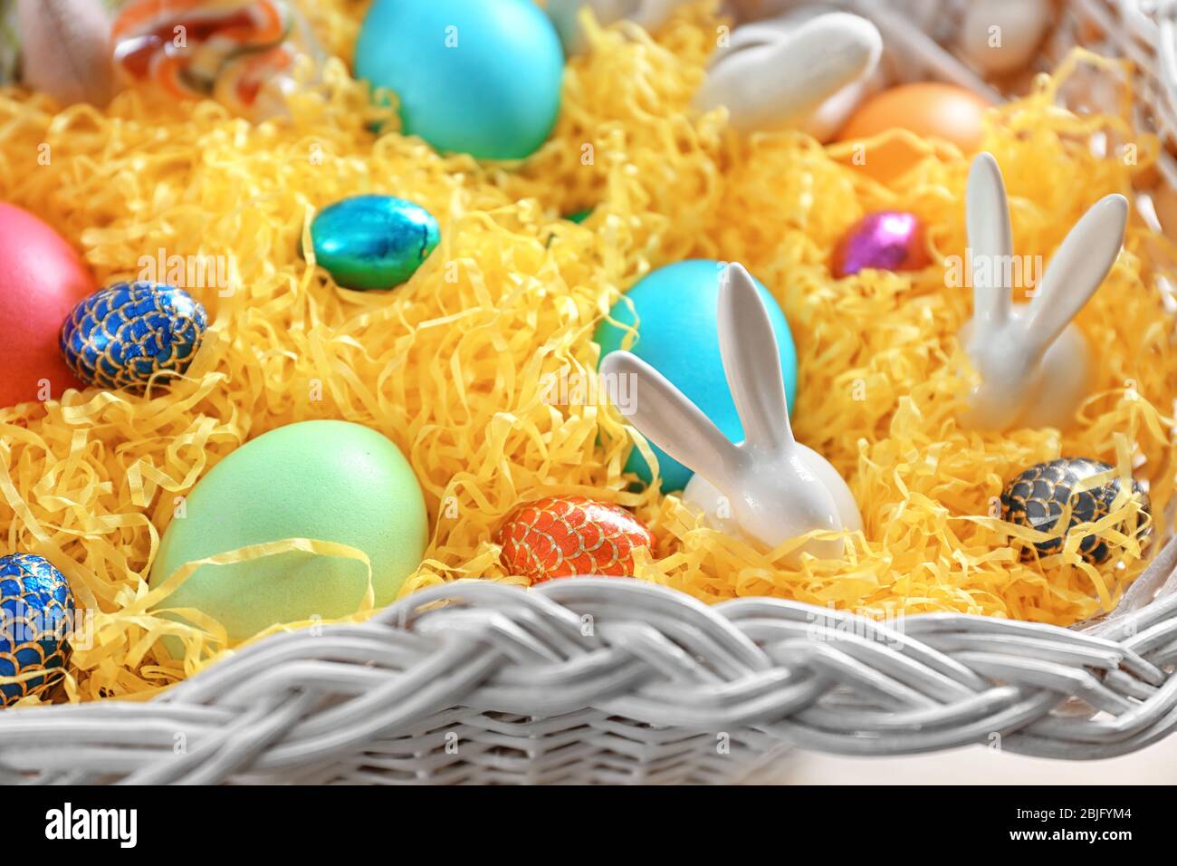 Easter eggs and decorative rabbits in white basket Stock Photo - Alamy