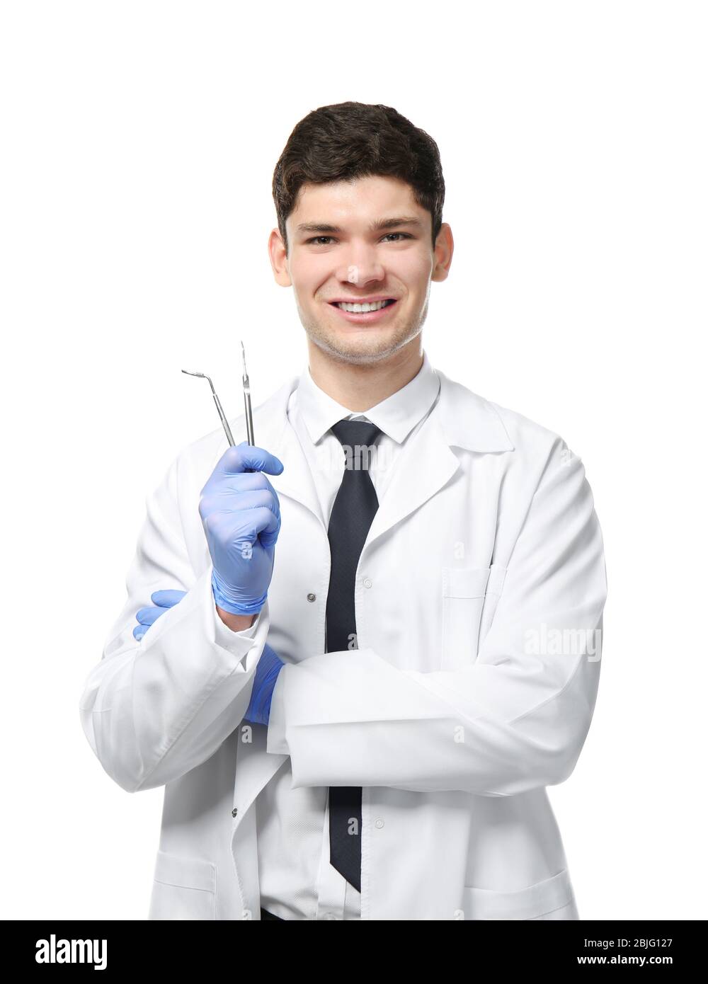 Handsome young dentist with tools on white background Stock Photo Alamy