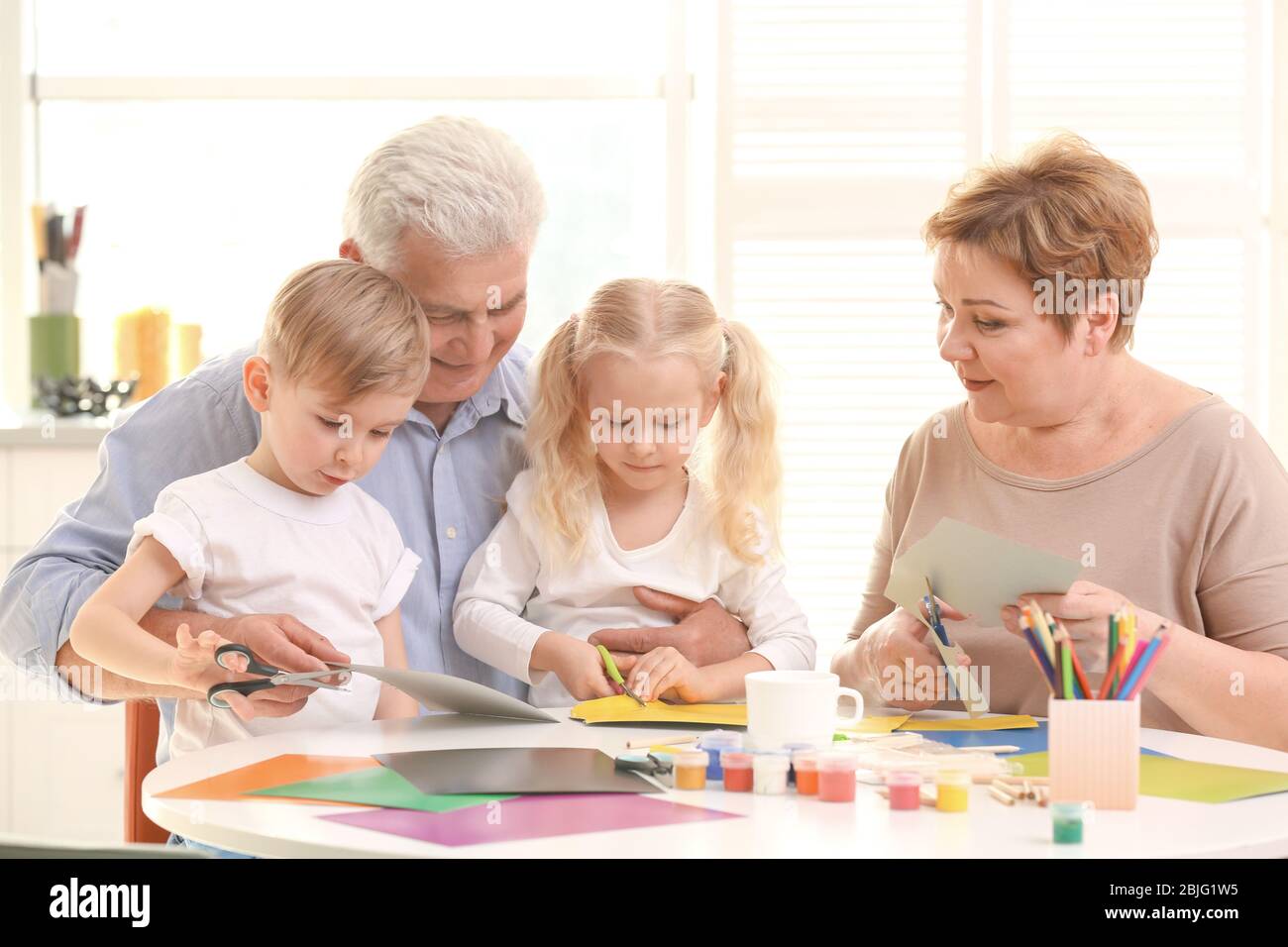 Grandparents and grandchildren spending time together at home Stock Photo
