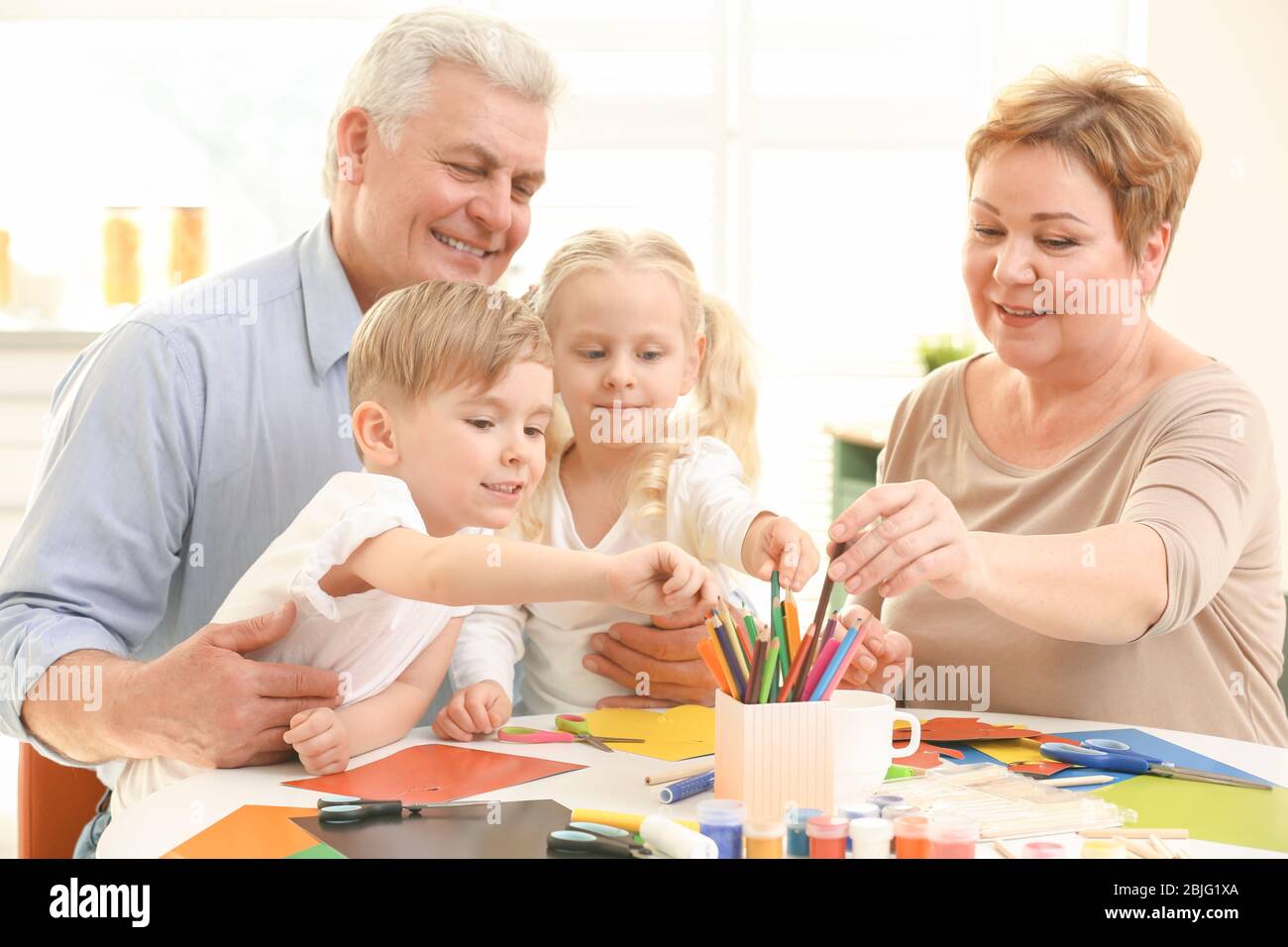 Grandparents and grandchildren spending time together at home Stock Photo