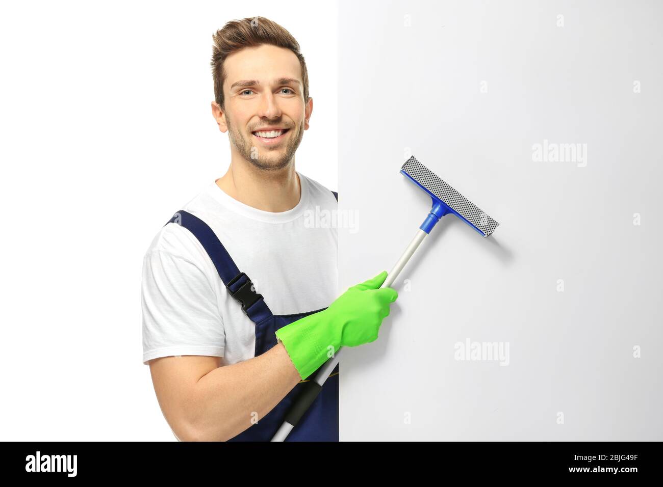 Young window cleaner with poster on white background Stock Photo