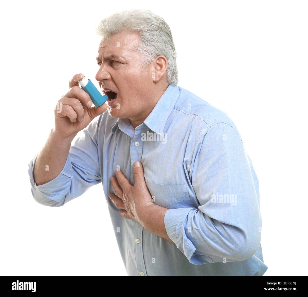 Elderly man using inhaler on white background Stock Photo