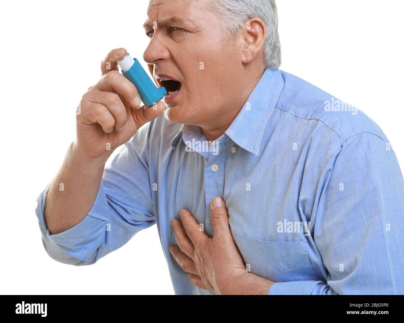 Elderly man using inhaler on white background Stock Photo