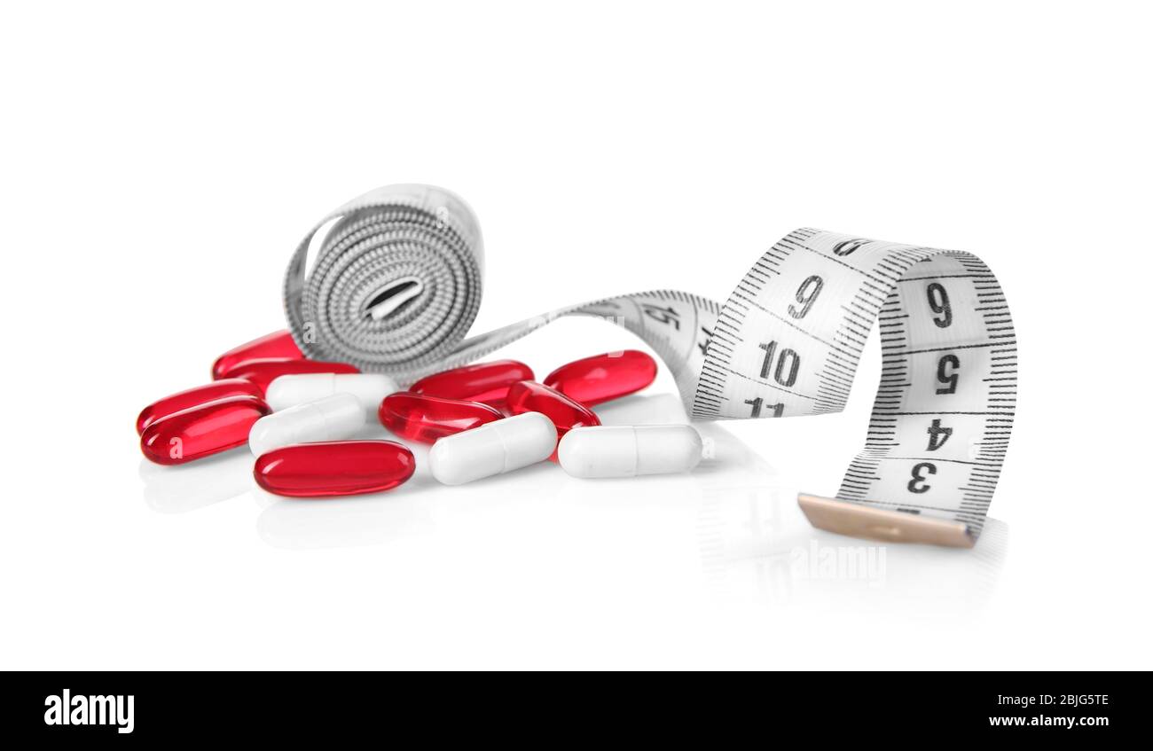 Diet concept. Measuring tape and pills on white background Stock Photo ...