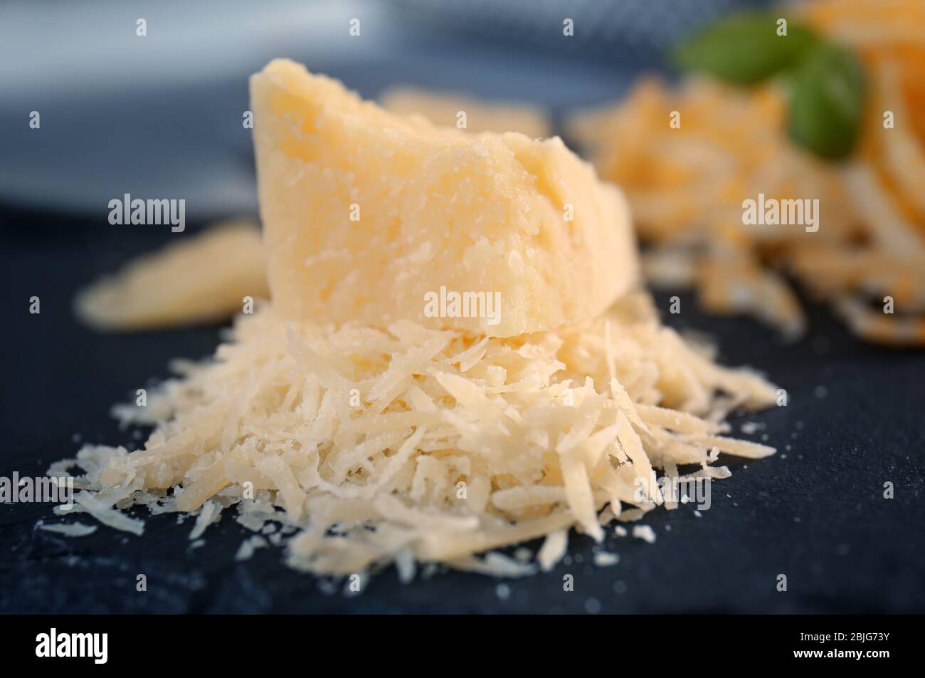 https://c8.alamy.com/comp/2BJG73Y/slate-plate-with-grated-cheese-on-table-2BJG73Y.jpg