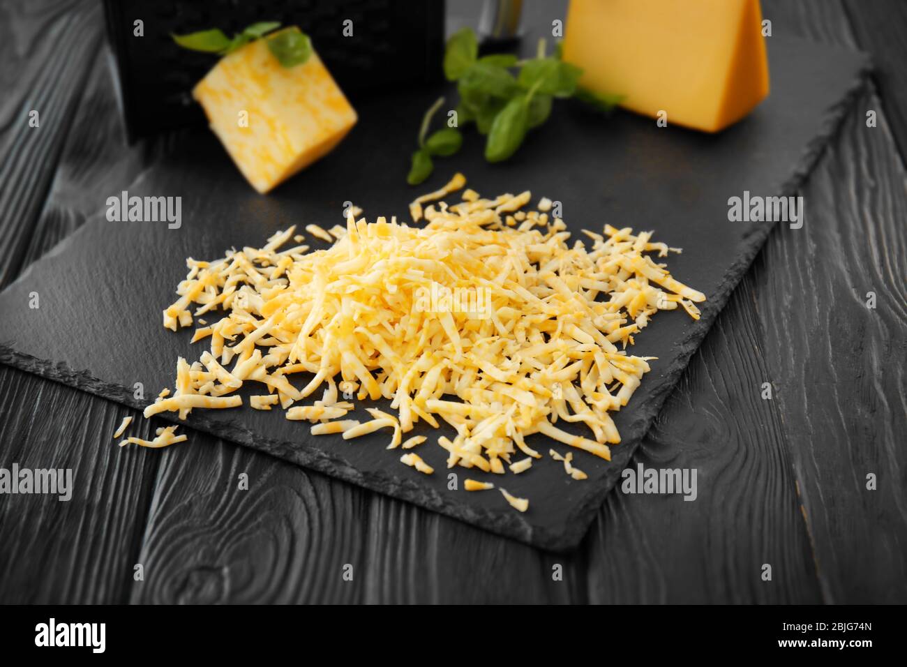 https://c8.alamy.com/comp/2BJG74N/slate-plate-with-grated-cheese-on-wooden-table-2BJG74N.jpg