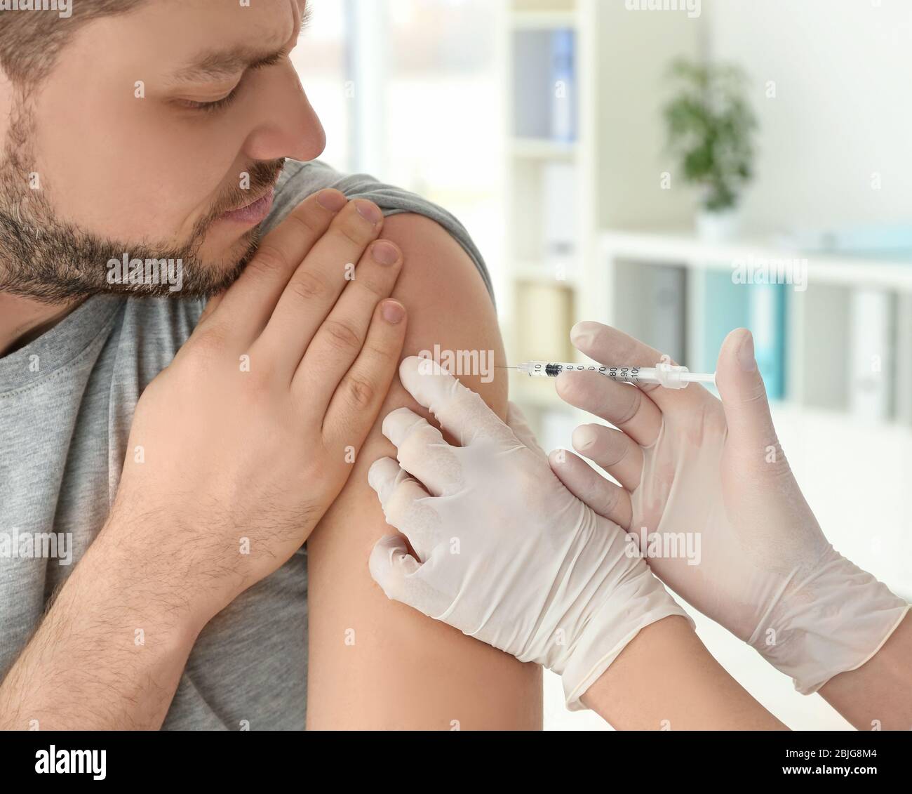 Vaccination concept. Female doctor vaccinating young man Stock Photo ...