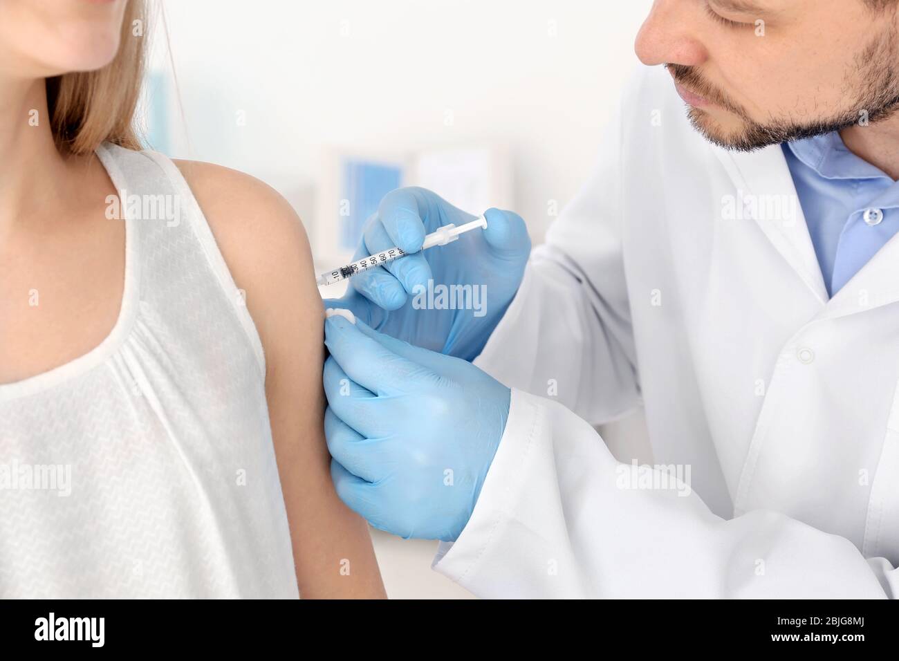 Vaccination concept. Male doctor vaccinating young woman Stock Photo ...