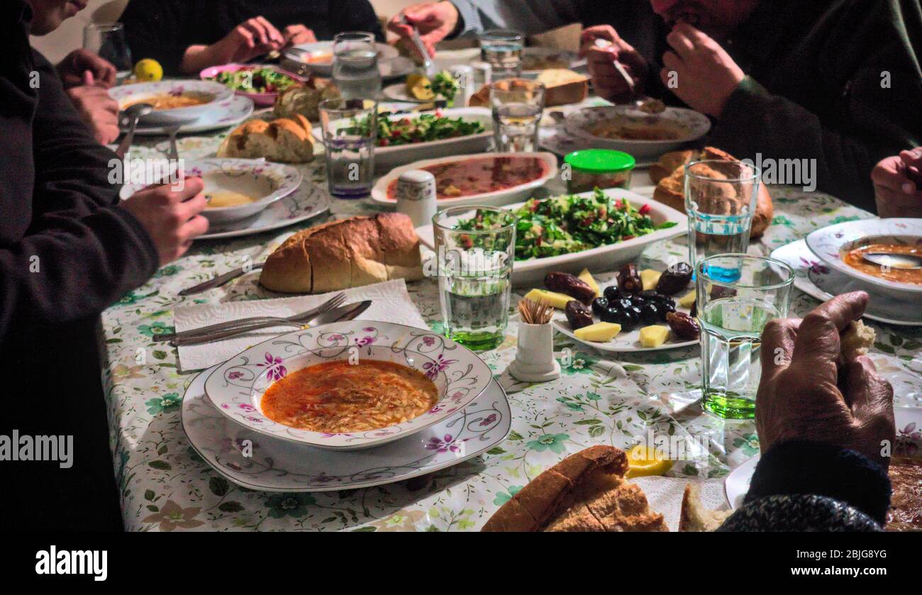 Crowded Turkish Muslim family having iftar together in happiness with delicious vegan food on the table Stock Photo