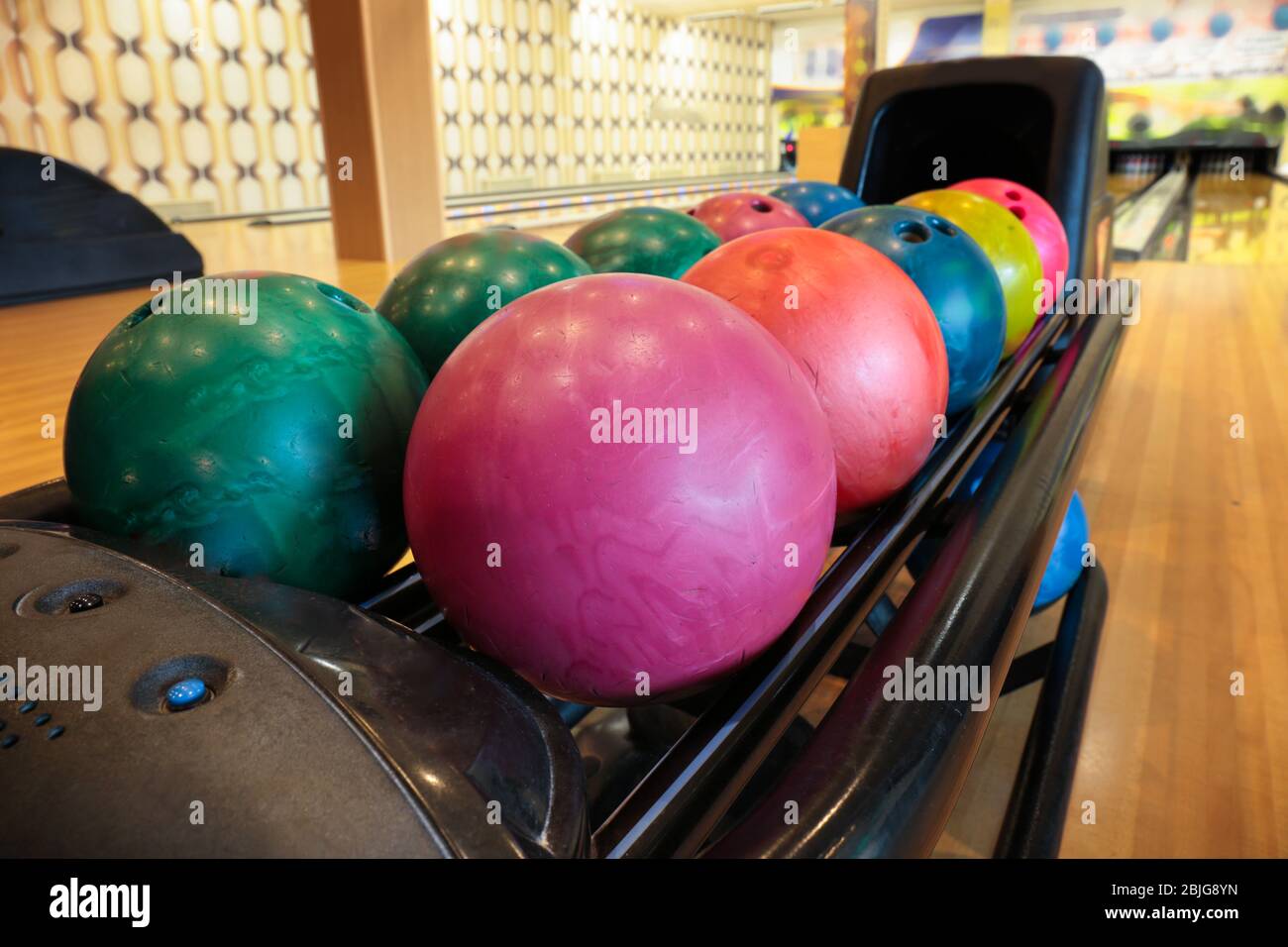 Colorful bowling balls in return machine Stock Photo Alamy
