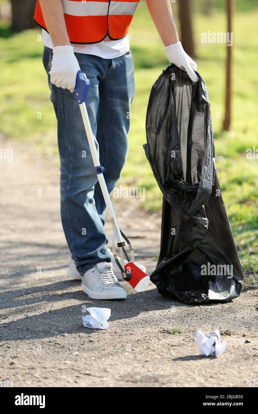 Young volunteer picking up litter in park Stock Photo Alamy