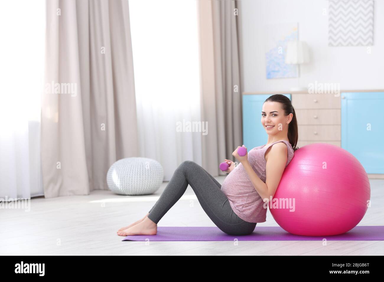 Beautiful pregnant woman doing exercise at home Stock Photo - Alamy