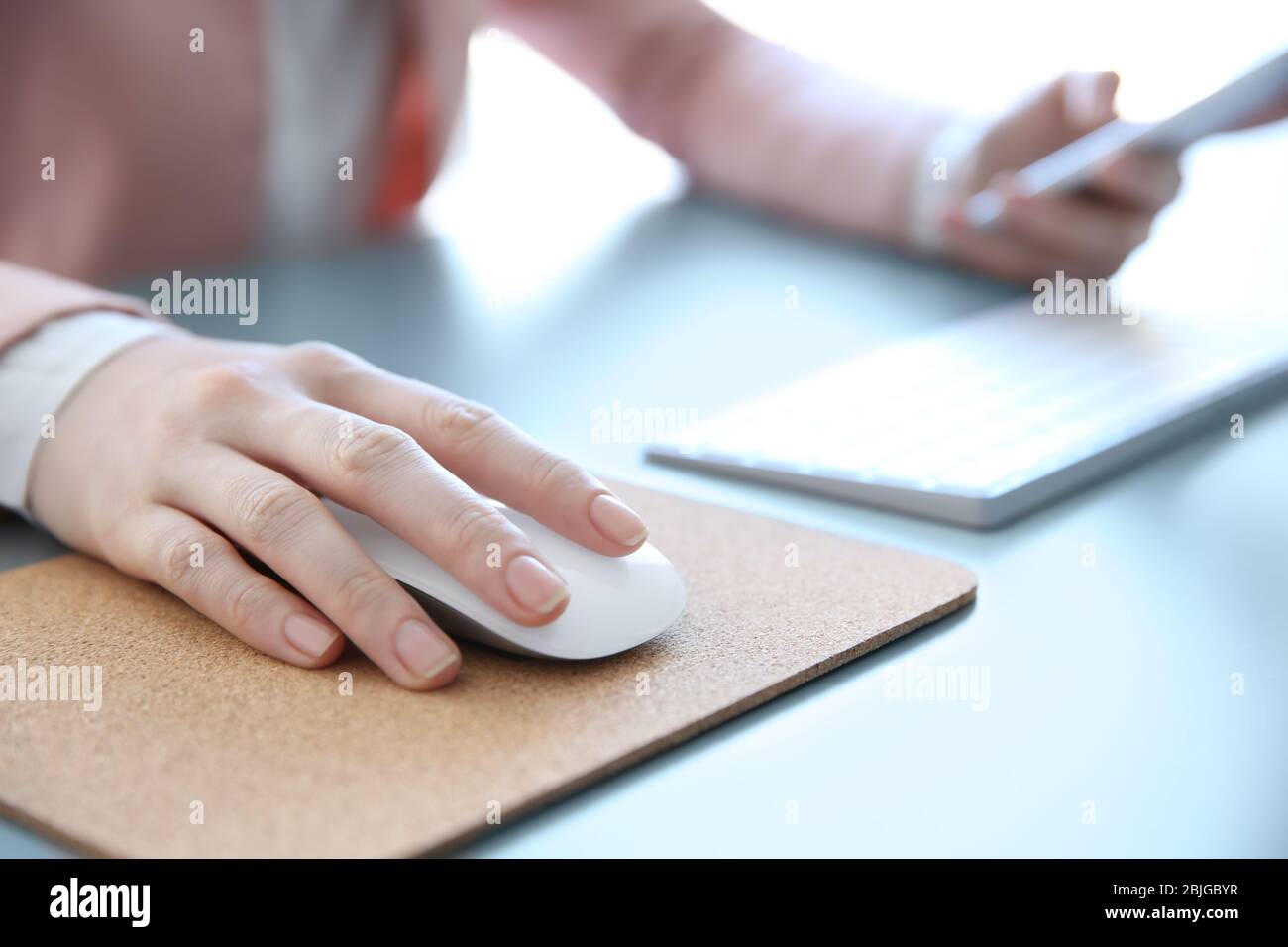 Female hand holding computer mouse on pad Stock Photo