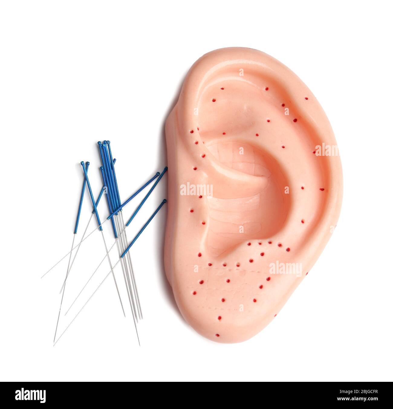 Needles for acupuncture and plastic mockup of human ear on white