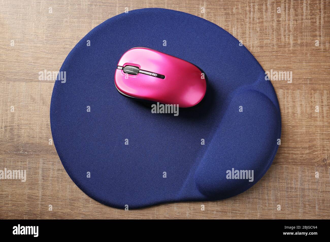Modern wireless mouse and pad on wooden background Stock Photo