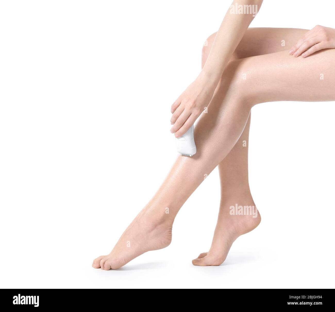 Beautiful young woman epilating legs on white background Stock Photo