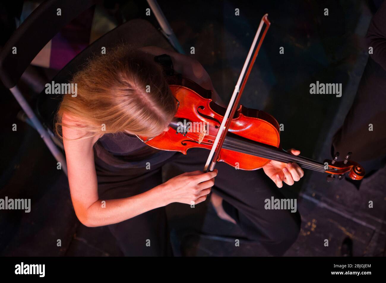 Overhead view of violin player (model released) performing in classical orchestra. Stock Photo