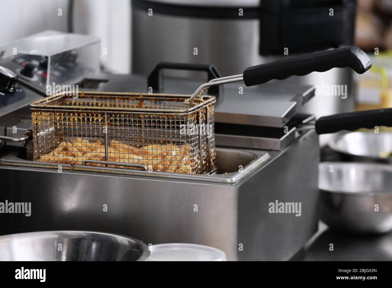 French fries in deep fryer on kitchen Stock Photo Alamy