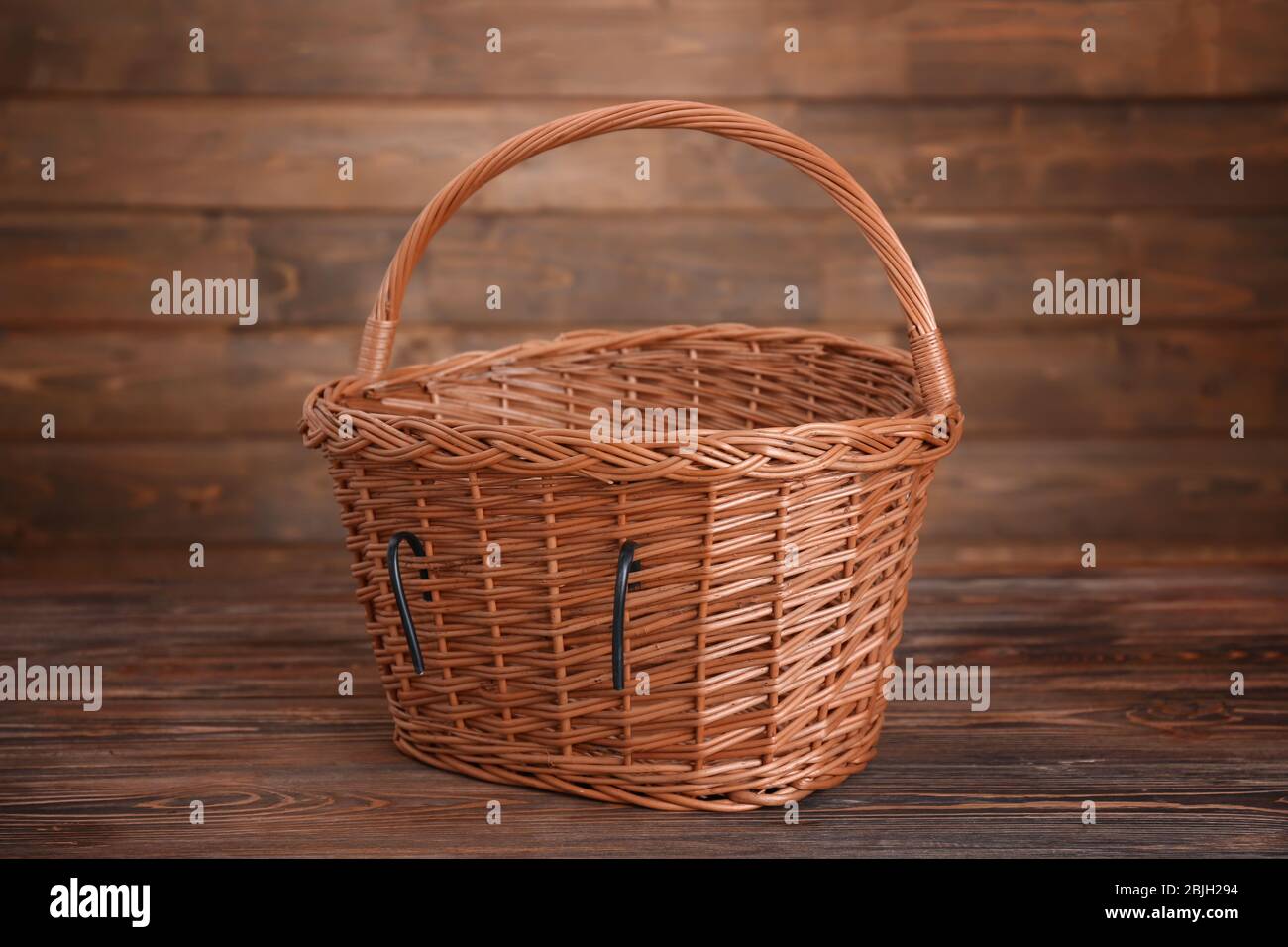 Bicycle wicker basket on wooden table Stock Photo