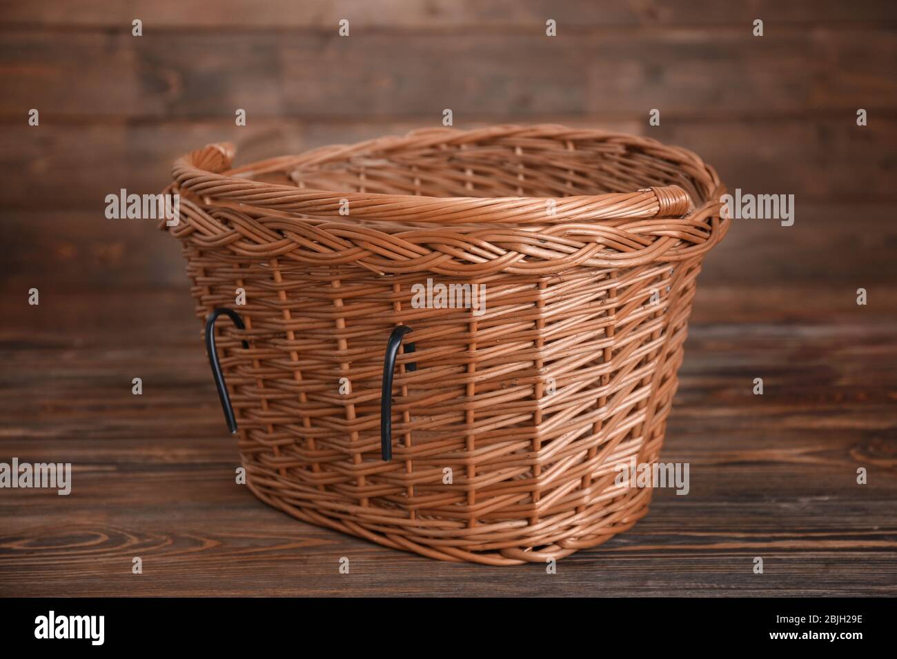 Bicycle wicker basket on wooden table Stock Photo