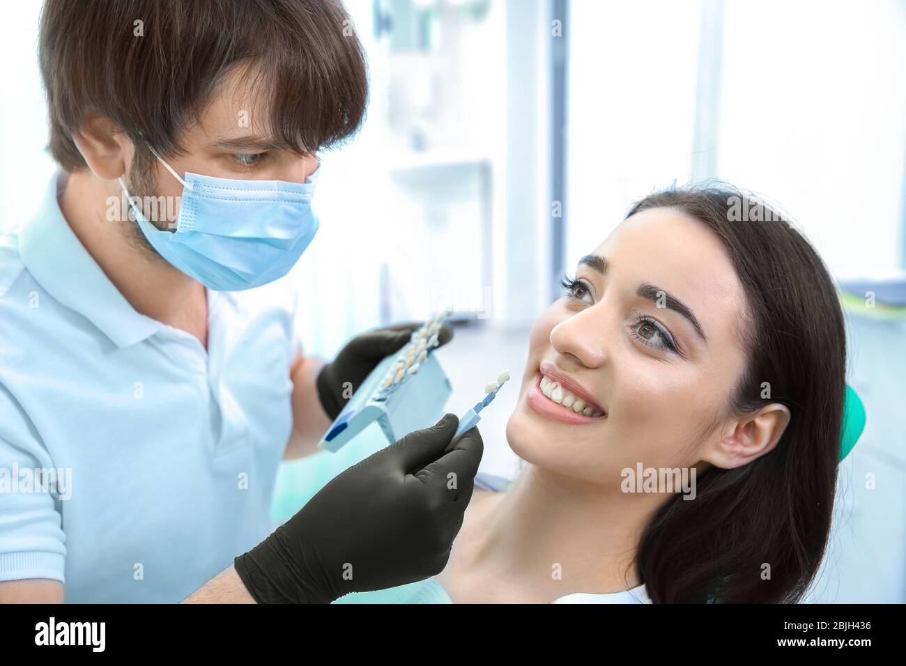 Dentist checking and selecting color of teeth in clinic Stock Photo