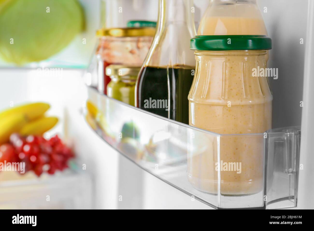 Different sauces on shelf in fridge Stock Photo Alamy