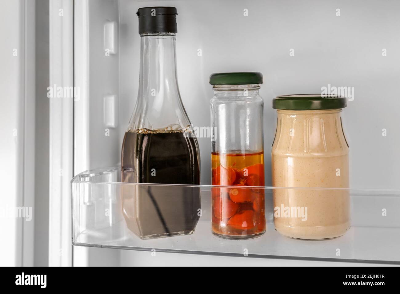 Different sauces on shelf in fridge Stock Photo Alamy