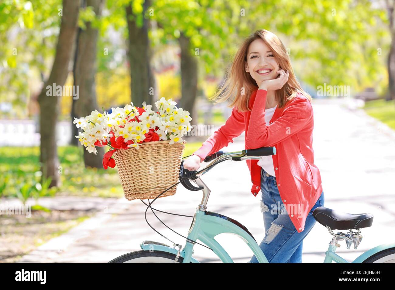 Young beautiful girl with bicycle in park on sunny day Stock Photo Alamy