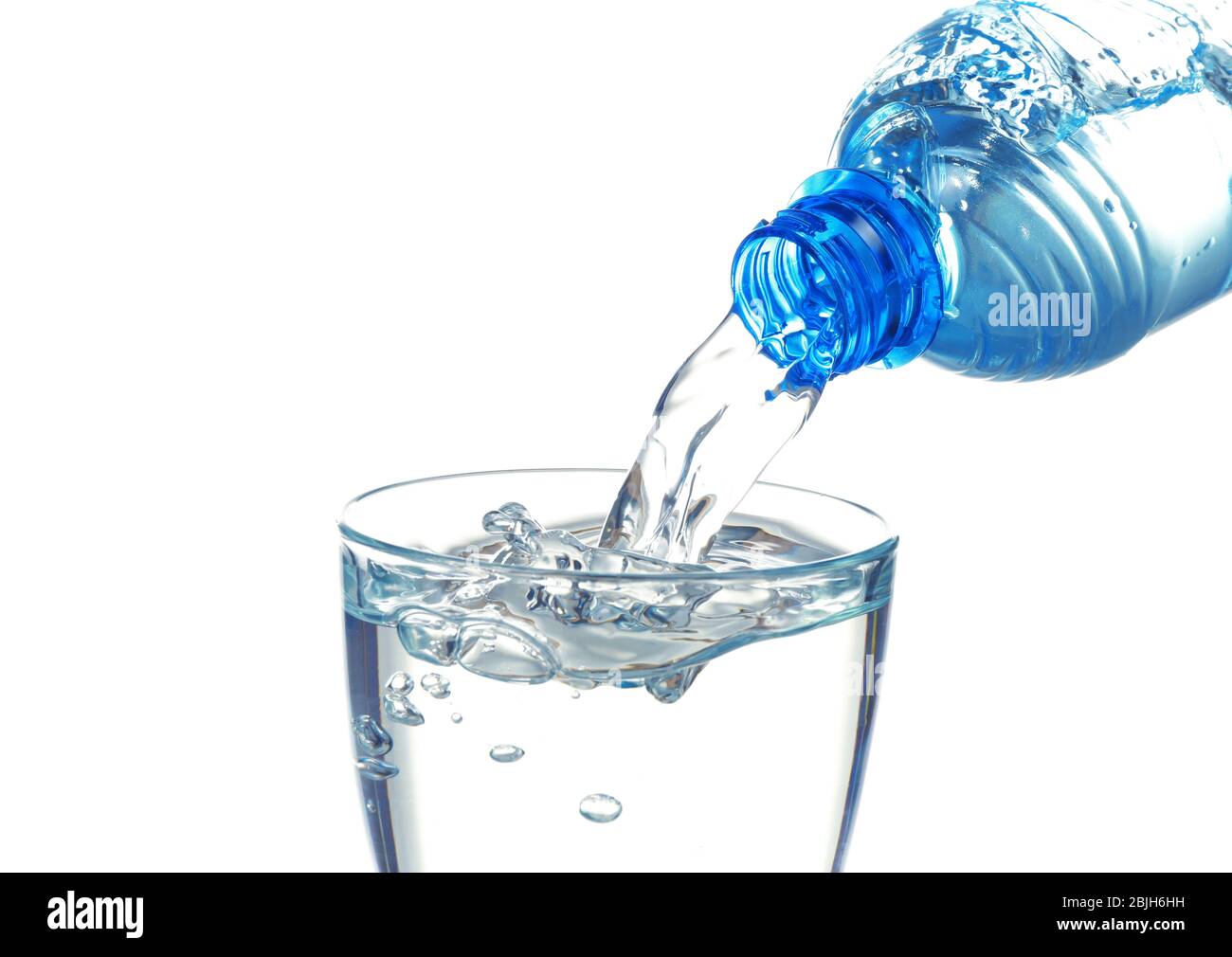 Water pouring from bottle into glass on white background Stock Photo ...