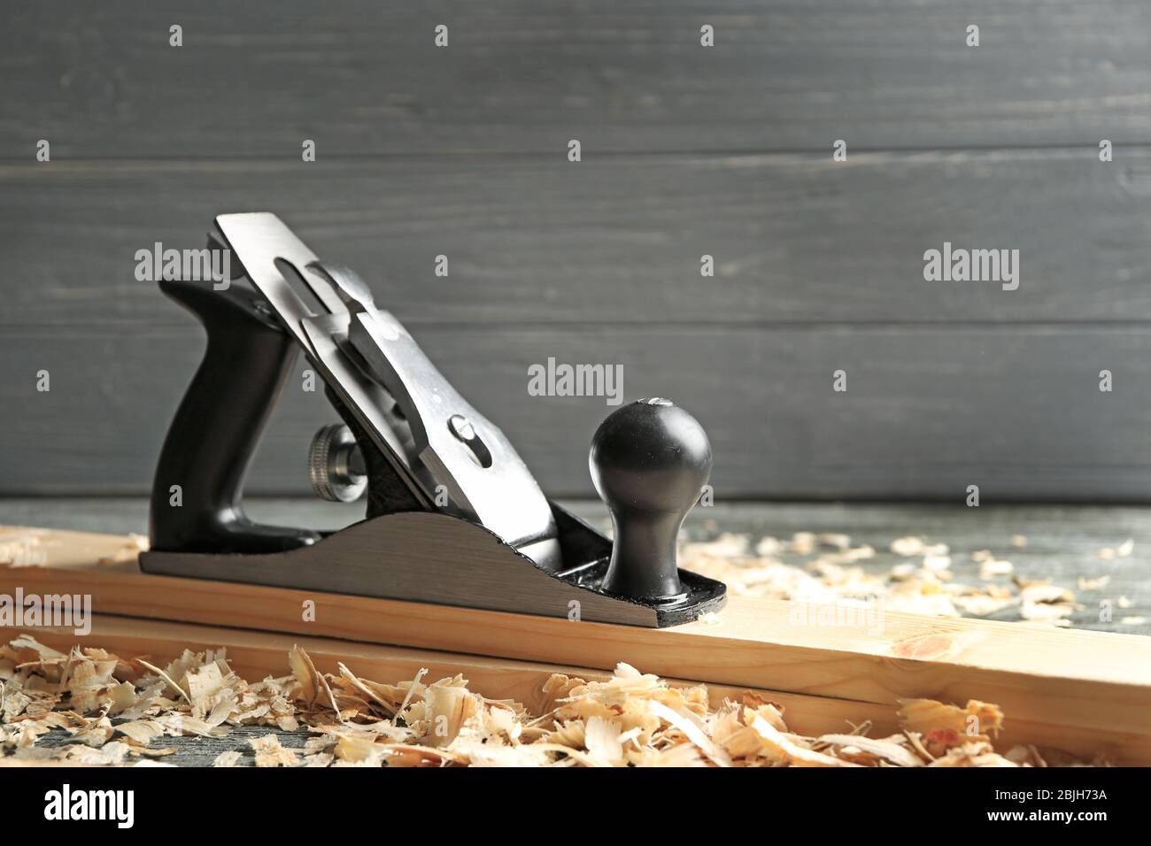 Bench plane, wooden boards and saw dust on table in carpenter's