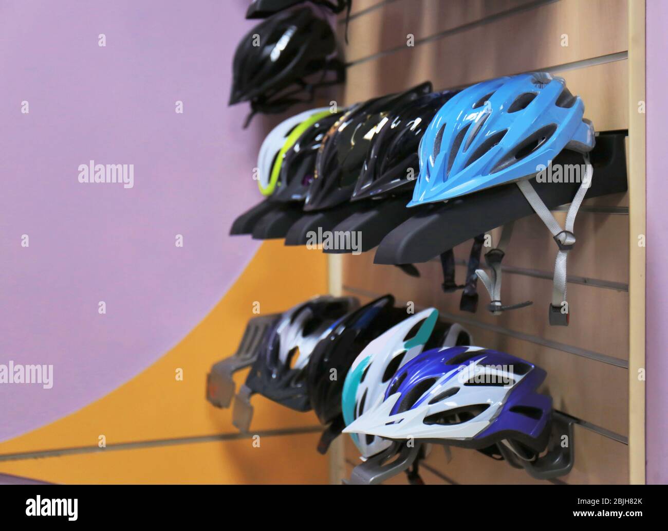 Stand with helmets in bicycle shop Stock Photo Alamy