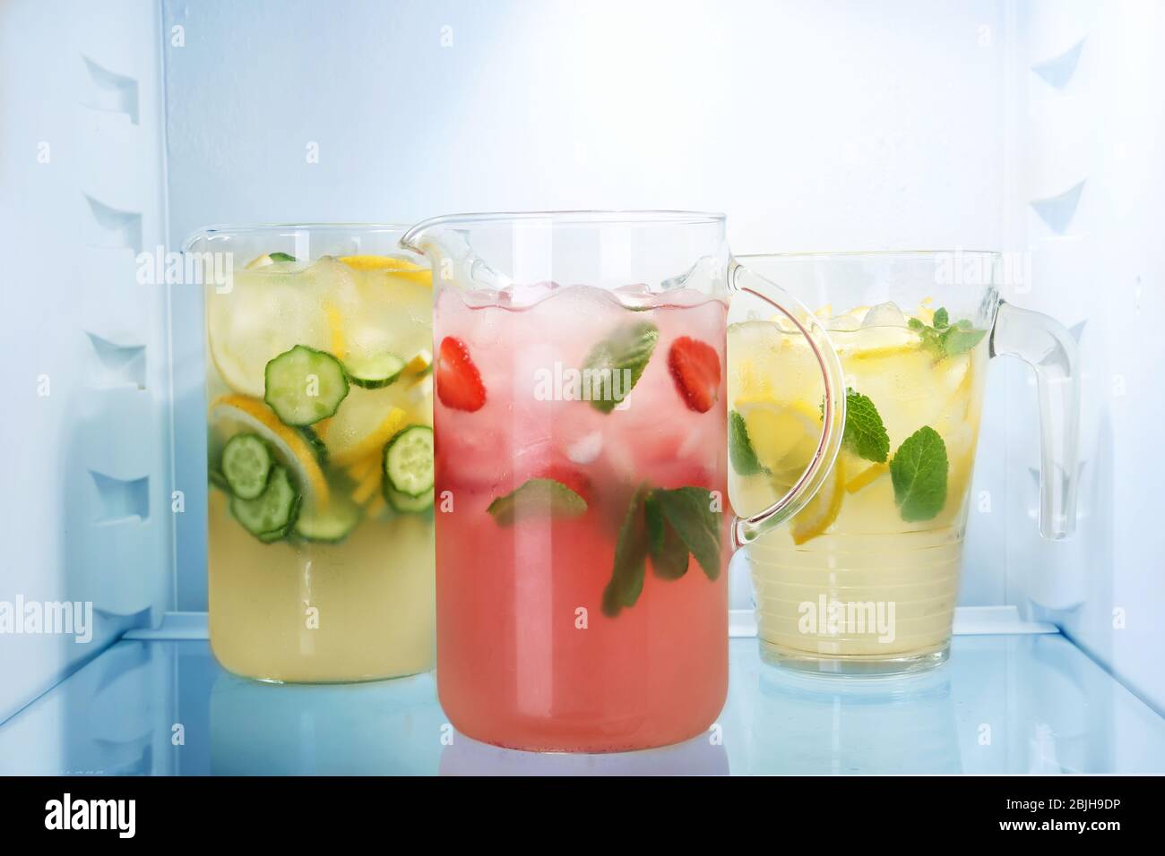 Jugs of fresh lemonade in fridge Stock Photo