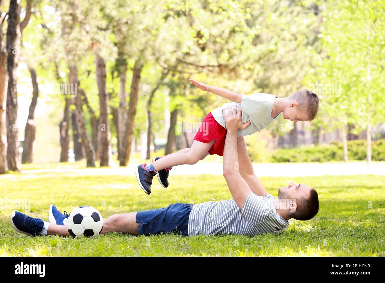 Father and son playing on green grass in park Stock Photo - Alamy