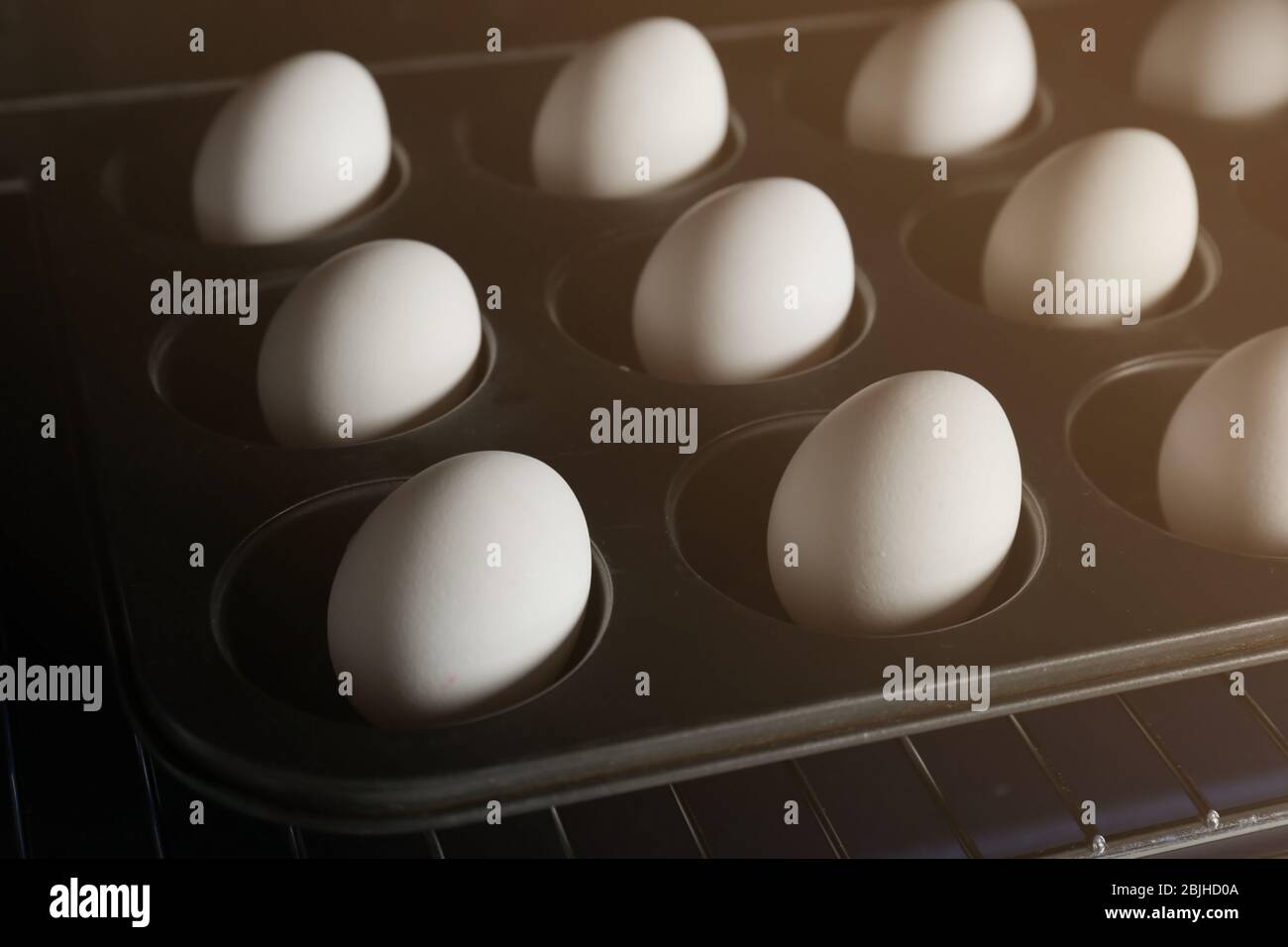 Muffin tin with hard boiled eggs in oven, closeup Stock Photo - Alamy