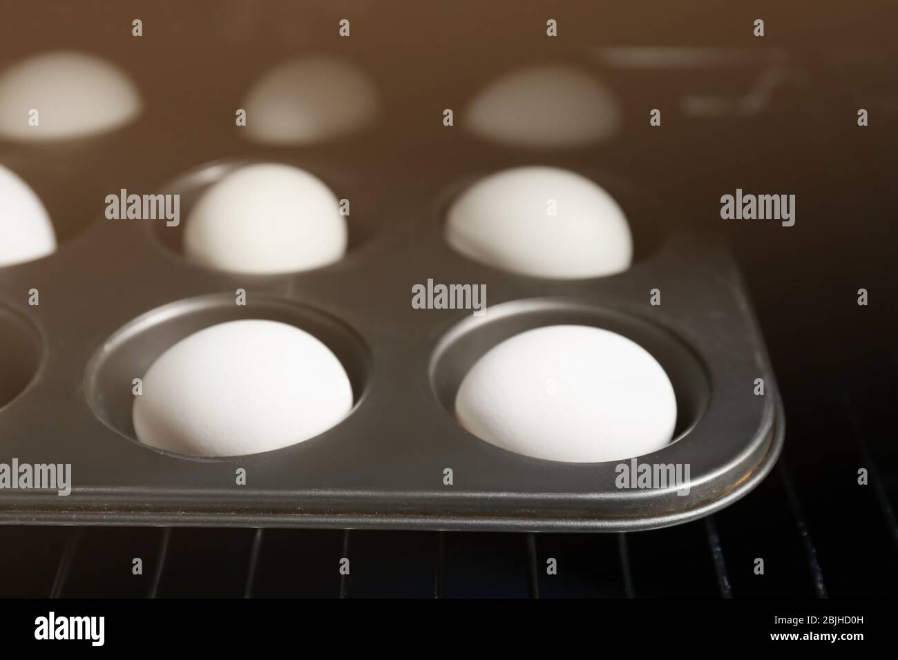 Muffin tin with hard boiled eggs in oven, closeup Stock Photo Alamy