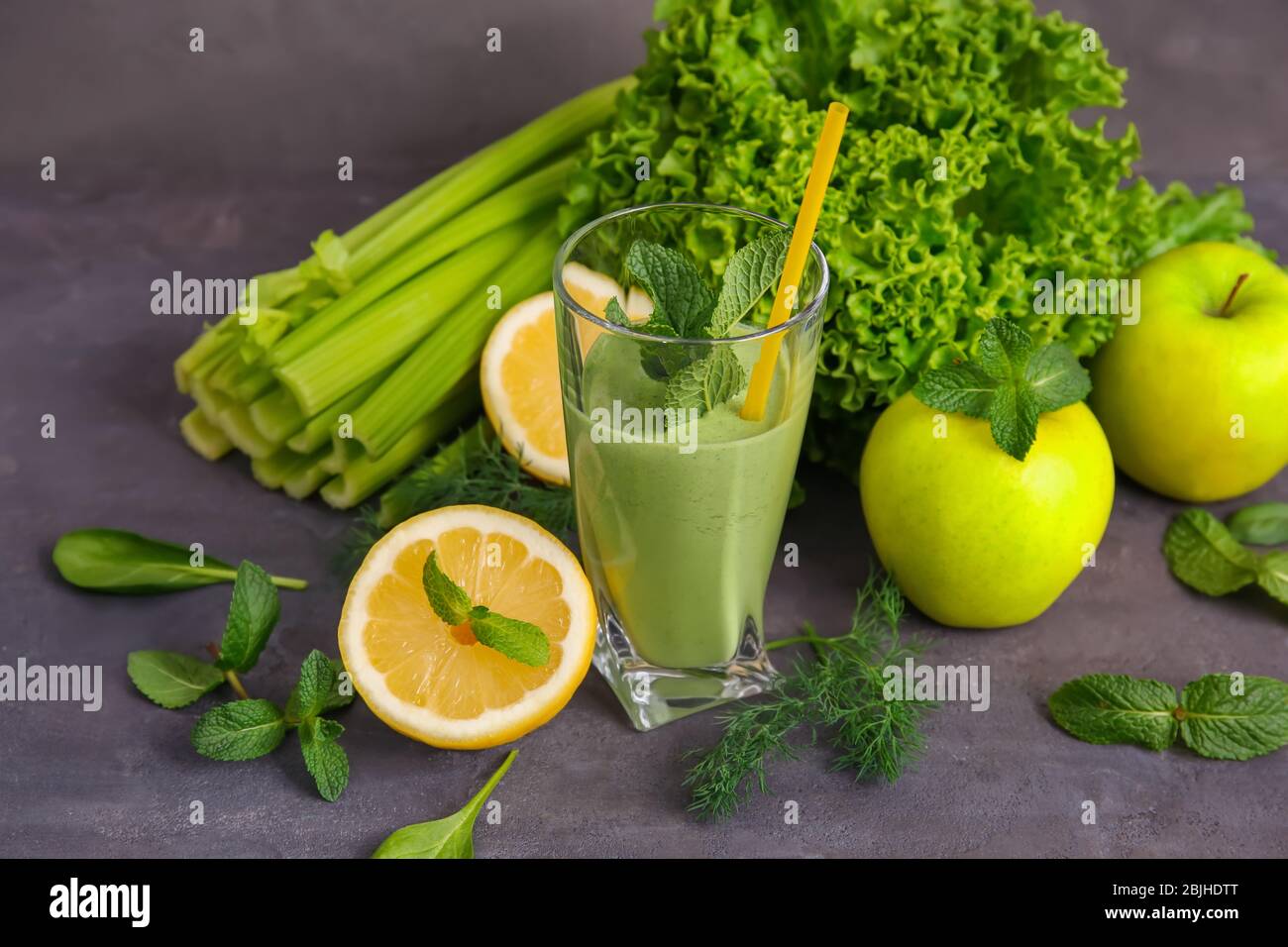 Glass of green healthy juice with fruits and vegetables on table Stock ...