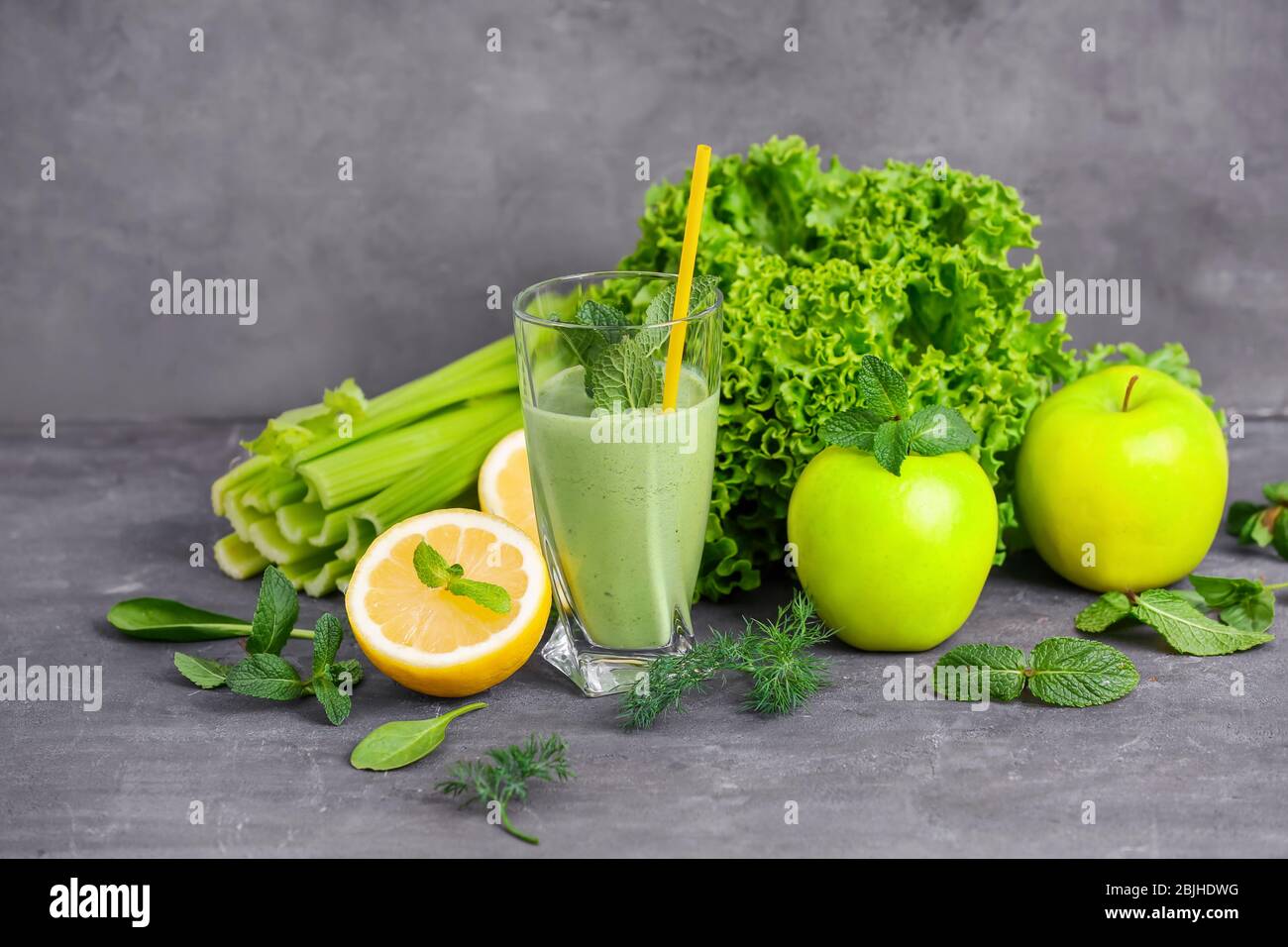 Glass of green healthy juice with fruits and vegetables on table Stock ...
