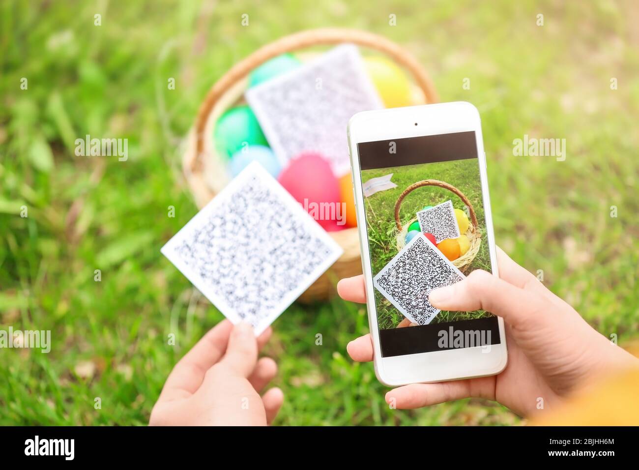 Woman scanning QR Code at park. Easter egg hunt concept Stock Photo Alamy