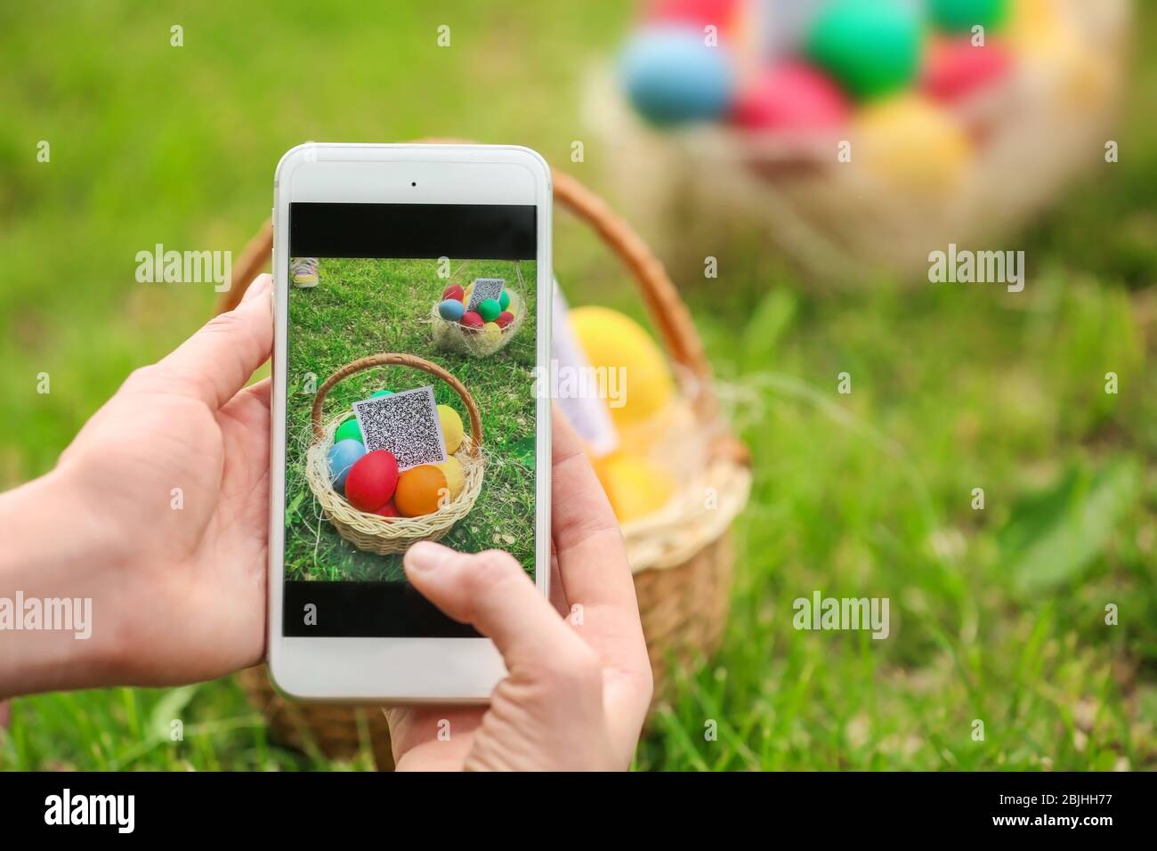 Woman scanning QR Code at park. Easter egg hunt concept Stock Photo Alamy