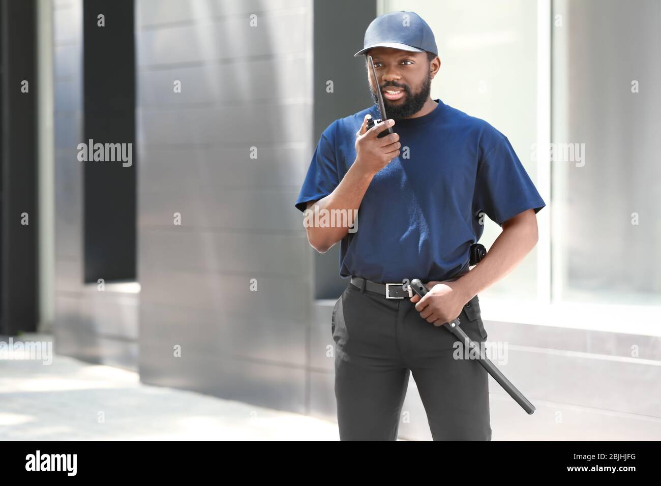 Male security guard using portable radio transmitter outdoors Stock Photo Alamy