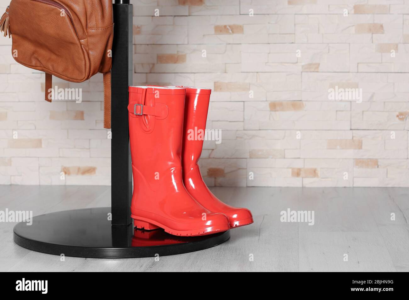 Red wellington boots and hall-stand near brick wall Stock Photo - Alamy
