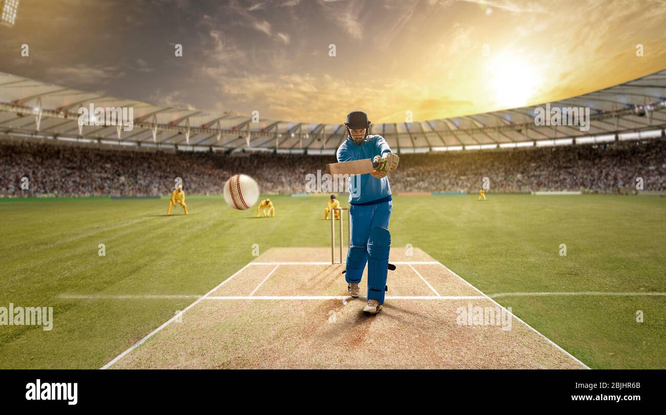 Young sportsman strikes the ball while batting in the cricket field Stock Photo