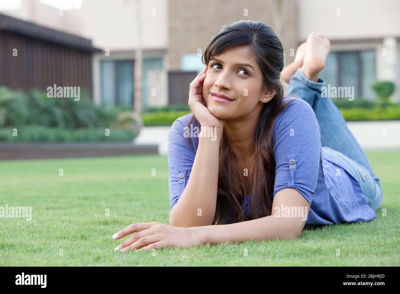 Woman lying on a lawn thinking Stock Photo