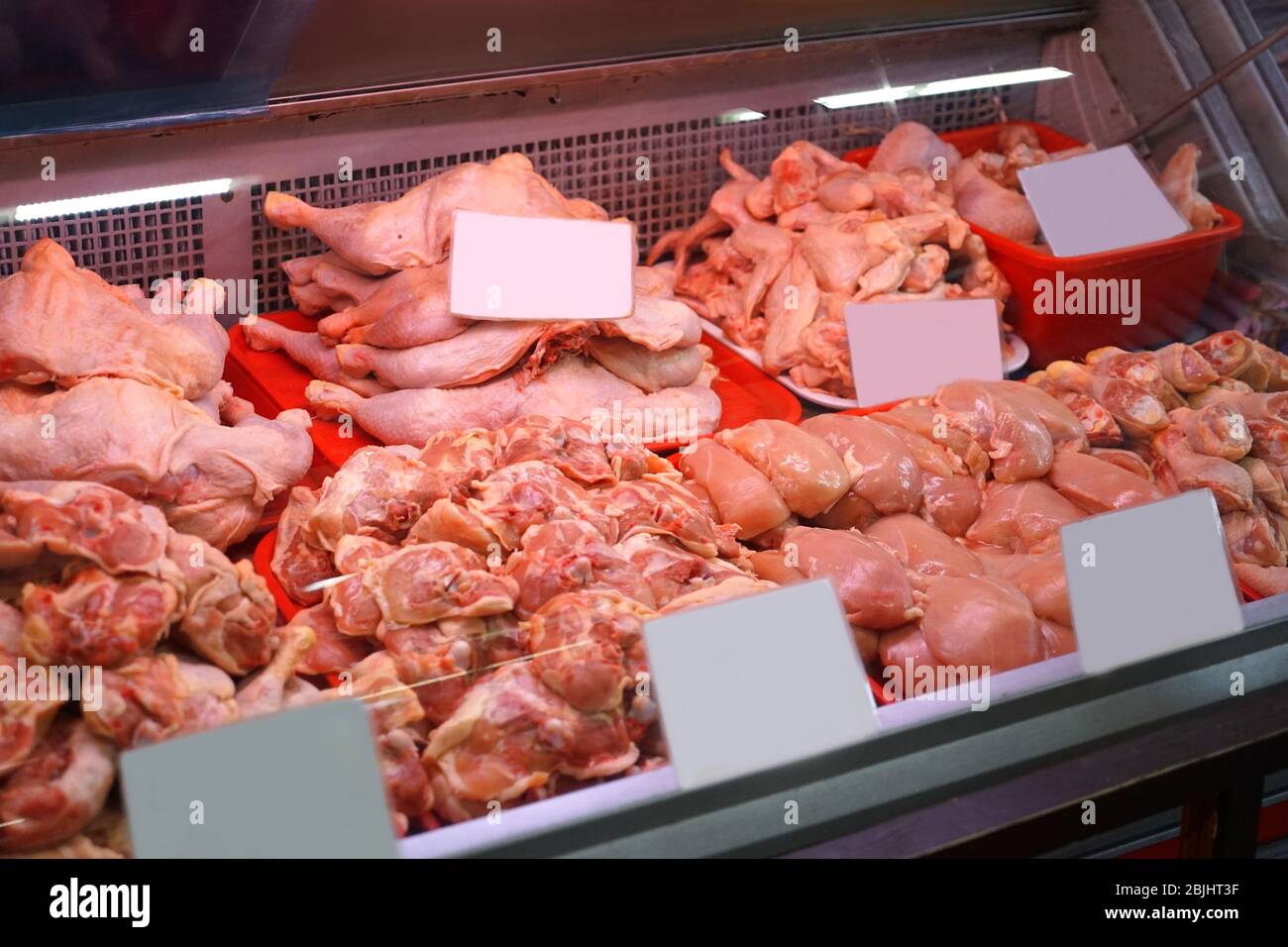 Fresh chicken parts and giblets in cooled display in supermarket Stock