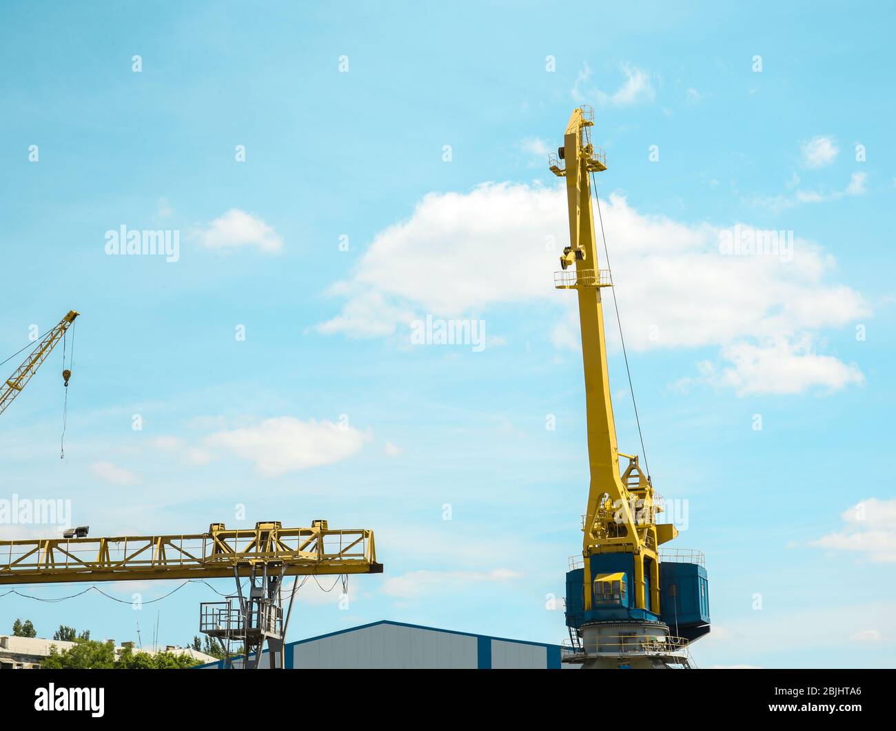 Hoisting cranes in dockyard Stock Photo