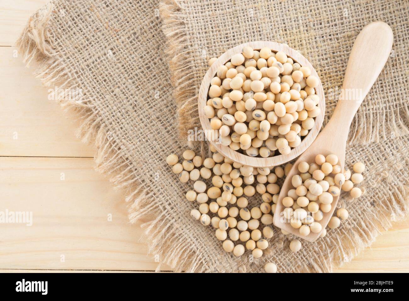 soybean in wood cup  on sack background Stock Photo