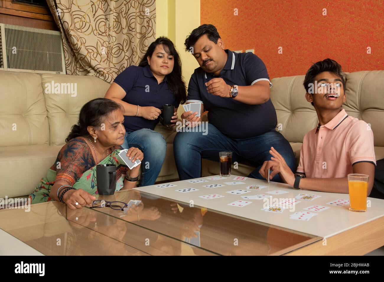 Happy family playing with cards in the living room at home Stock Photo -  Alamy